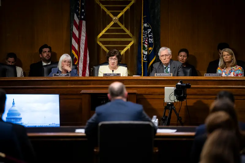 The back of Vought’s head is out of focus while the senators he’s facing are in focus looking at him.