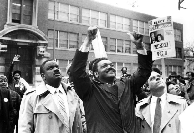 Rev. Jesse Jackson, center, campaigns in Cabrini Green with Aurelia Puchinski on March 15, 1988, when he was running for president of the United States. (Don Casper/Chicago Tribune)
