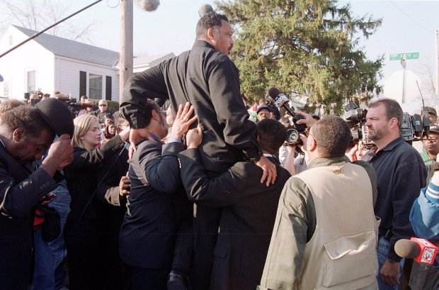 Members of the Rainbow/PUSH Coalition hoist their leader, the Rev. Jesse Jackson, so he can talk, Nov. 10, 1999, outside Eisenhower High School in Decatur. (Phil Greer/Chicago Tribune)