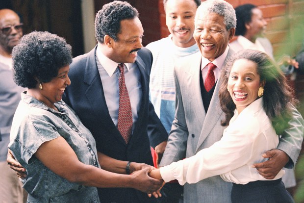 The Rev. Jesse Jackson, second from left, and Nelson Mandela stand with wives Winnie Mandela, left, and Jacqueline Jackson holding hands when the Jacksons visited he Mandela