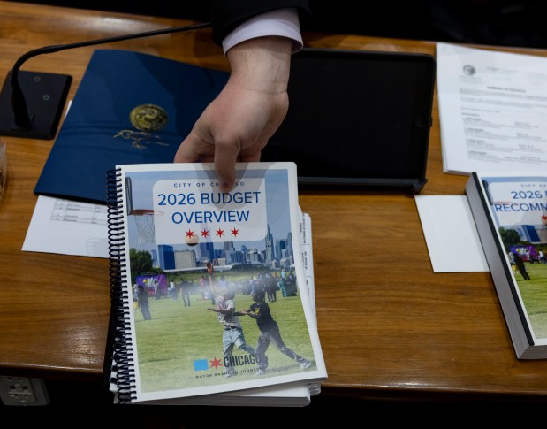 Copies of the budget overview are distributed to City Council members Oct. 16, 2025, after Mayor Brandon Johnson delivered his budget address at Chicago City Hall. (Brian Cassella/Chicago Tribune)