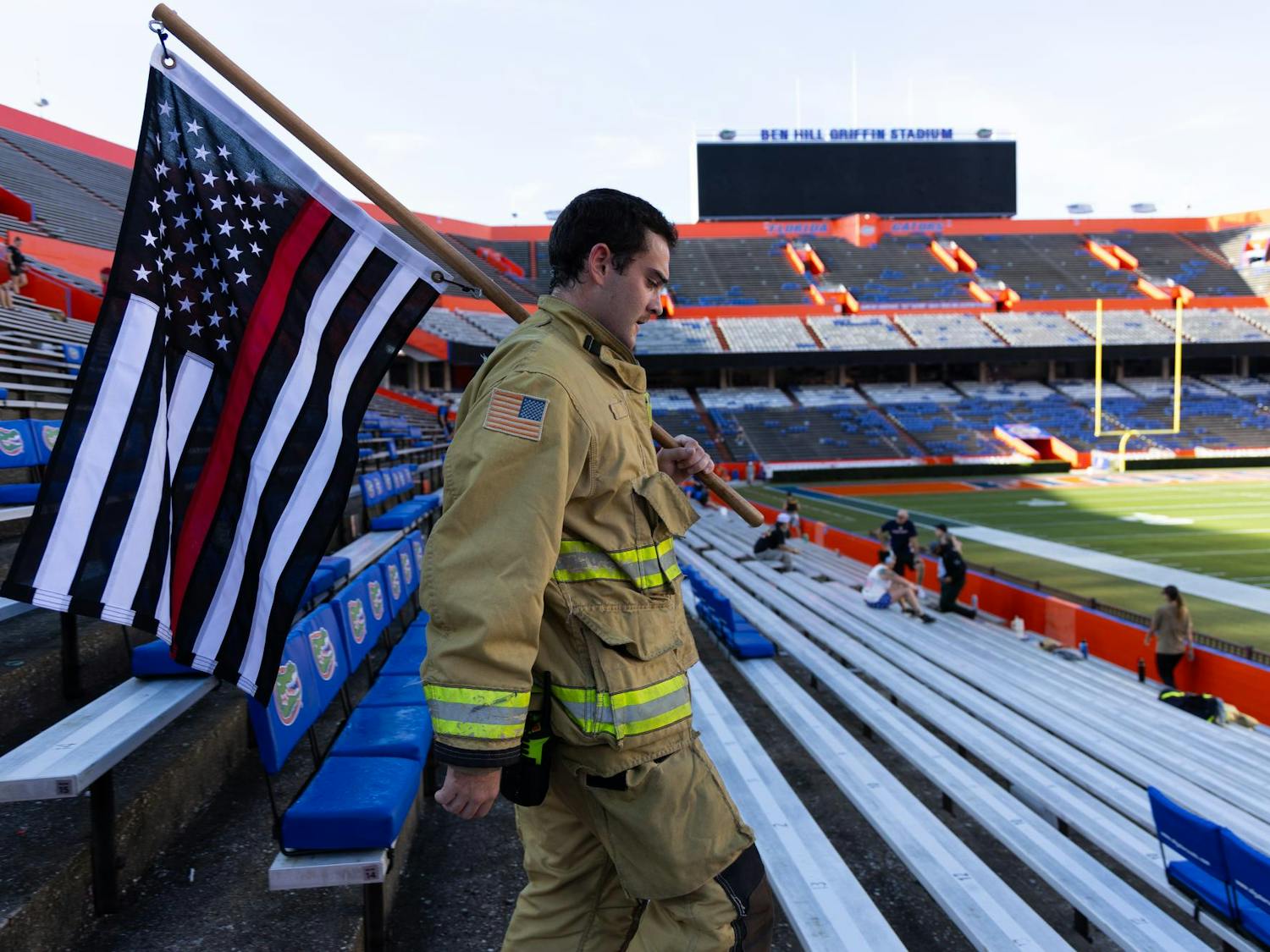 A firefighter carries an American thin red line flag while walking stairs in Ben Hill Griffin Stadium during the 9/11 climb, Friday Sept. 11, 2026, in Gainesville Fla.