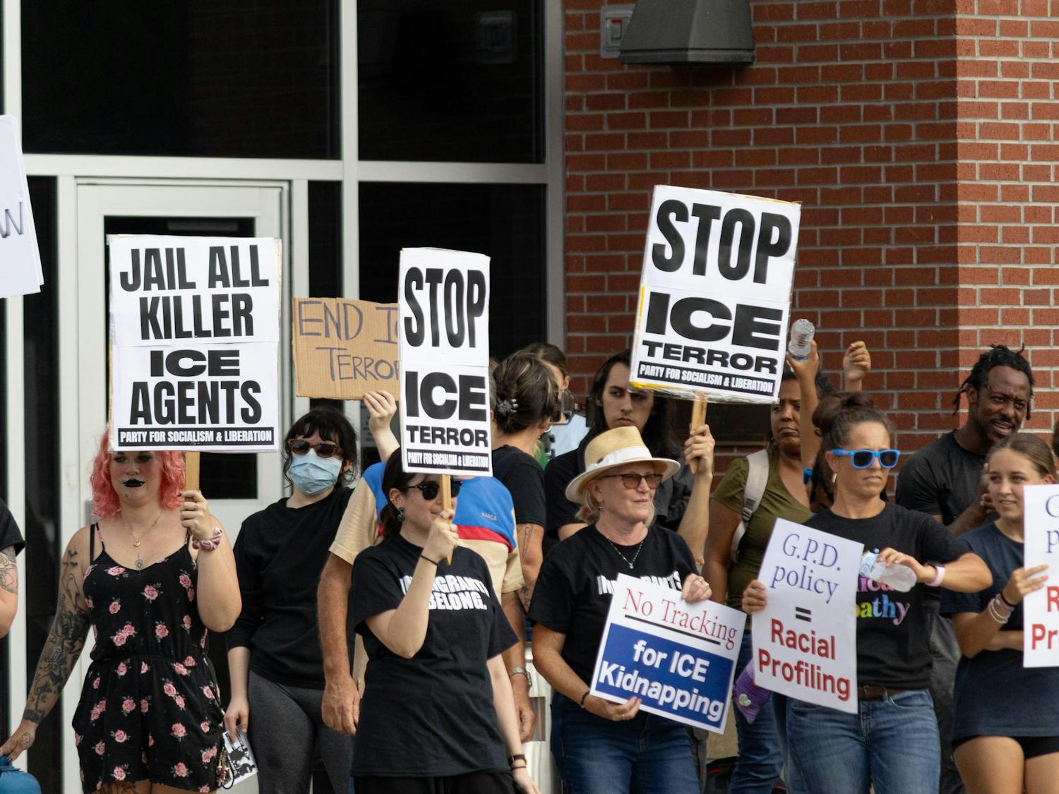 Protestors hold up signs at an anti-ICE protest in front of the GPD headquarters in Gainesville, Fla., Thursday, Sept. 3, 2026.