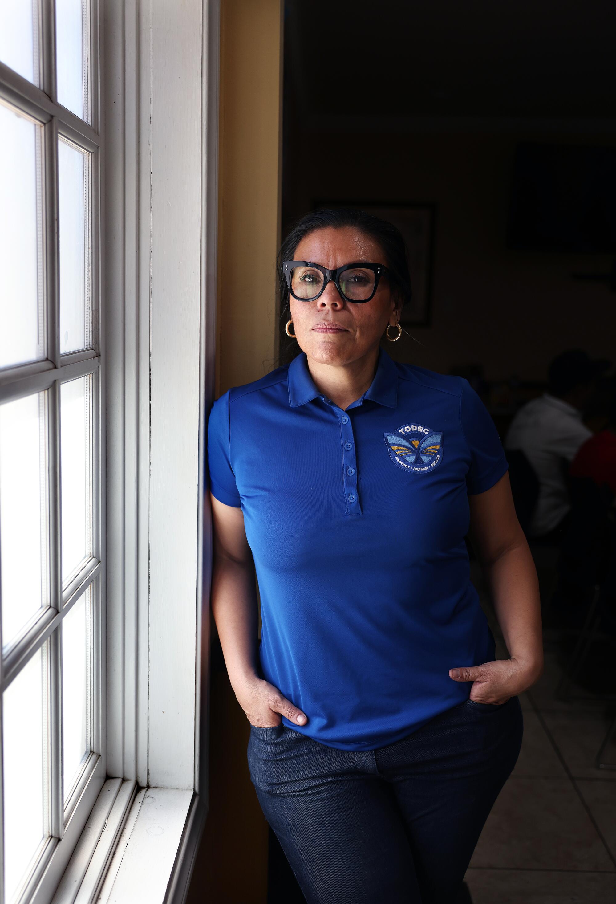  Executive Director Luz Gallegos stands near a window. 