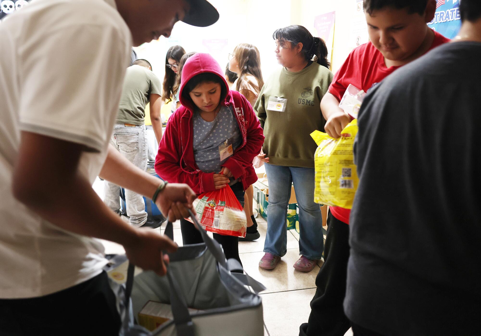 Children help pack food deliveries for people in their community who are afraid of leaving home because of ICE.