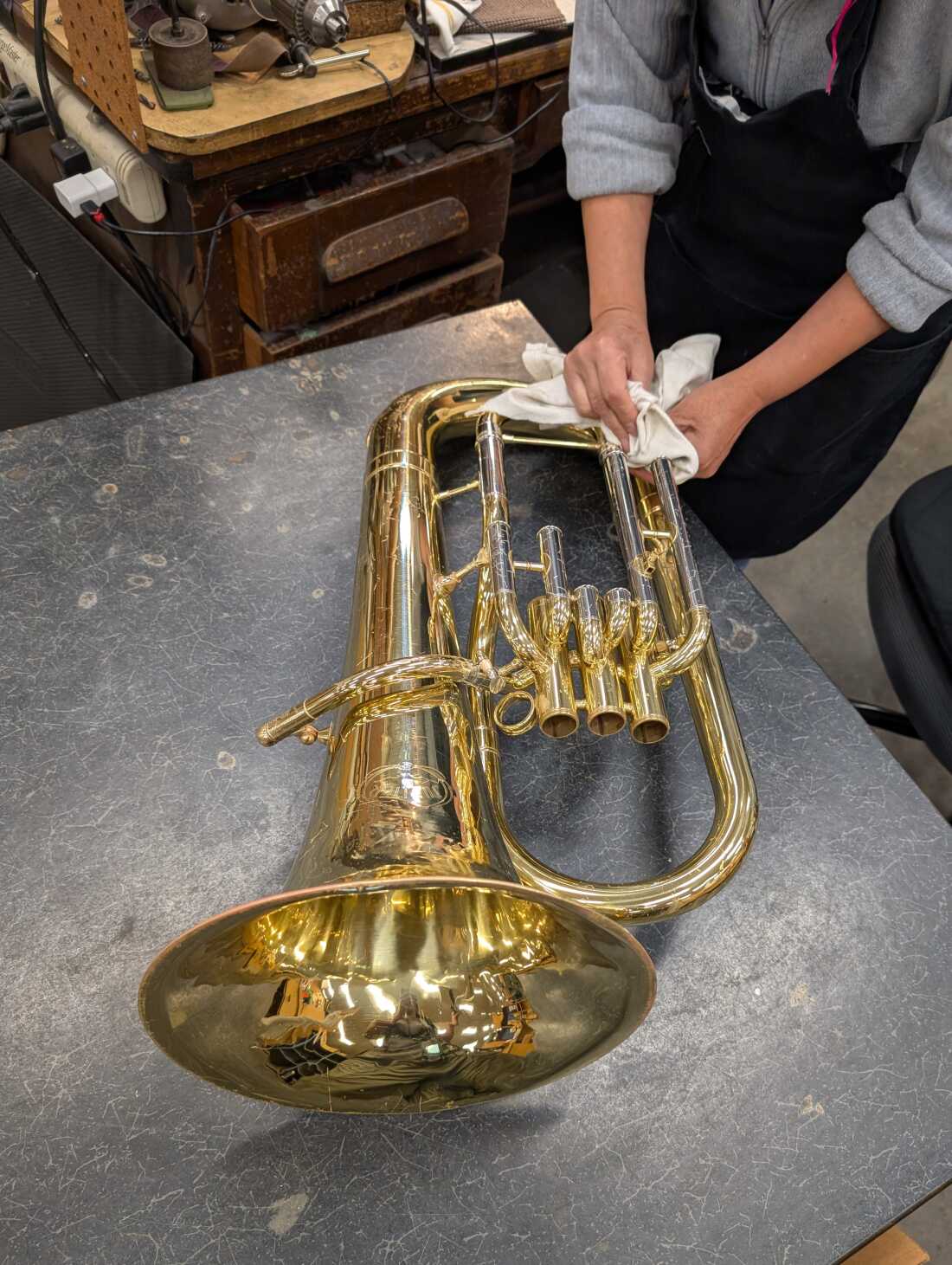 Technician Paty Moreno repairs a baritone horn.
