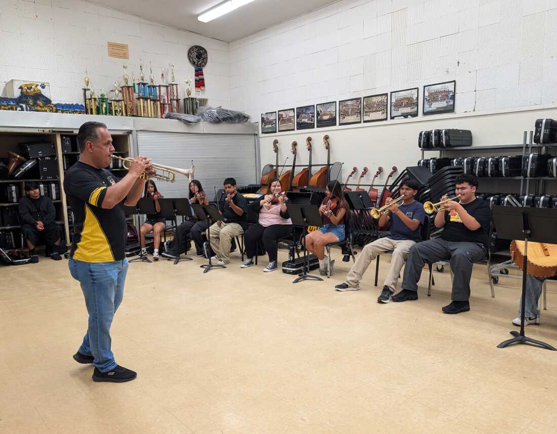 Sergio Alonso instructs the San Fernando High School mariachi band, while playing the trumpet.