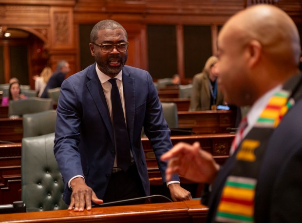 State Reps. La Shawn Ford (center) and Justin Slaughter talk before Gov. JB Pritzker delivers his annual budget address on Feb. 19, 2025, at the Illinois State Capitol in Springfield. (Brian Cassella/Chicago Tribune)