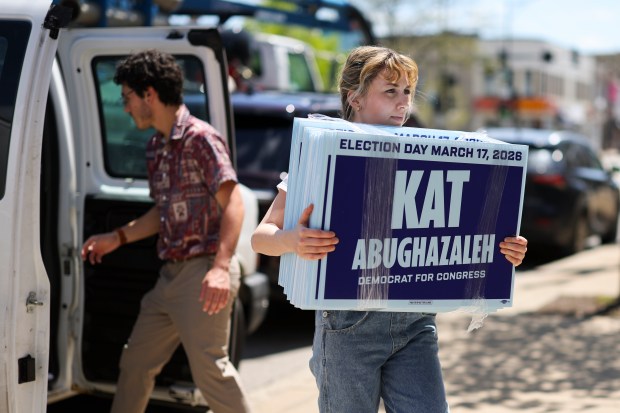 Kat Abughazaleh, who has announced a campaign for Illinois' 9th Congressional District, carries yard signs into her brand new campaign office in Rogers Park on May 6, 2025. (Eileen T. Meslar/Chicago Tribune)