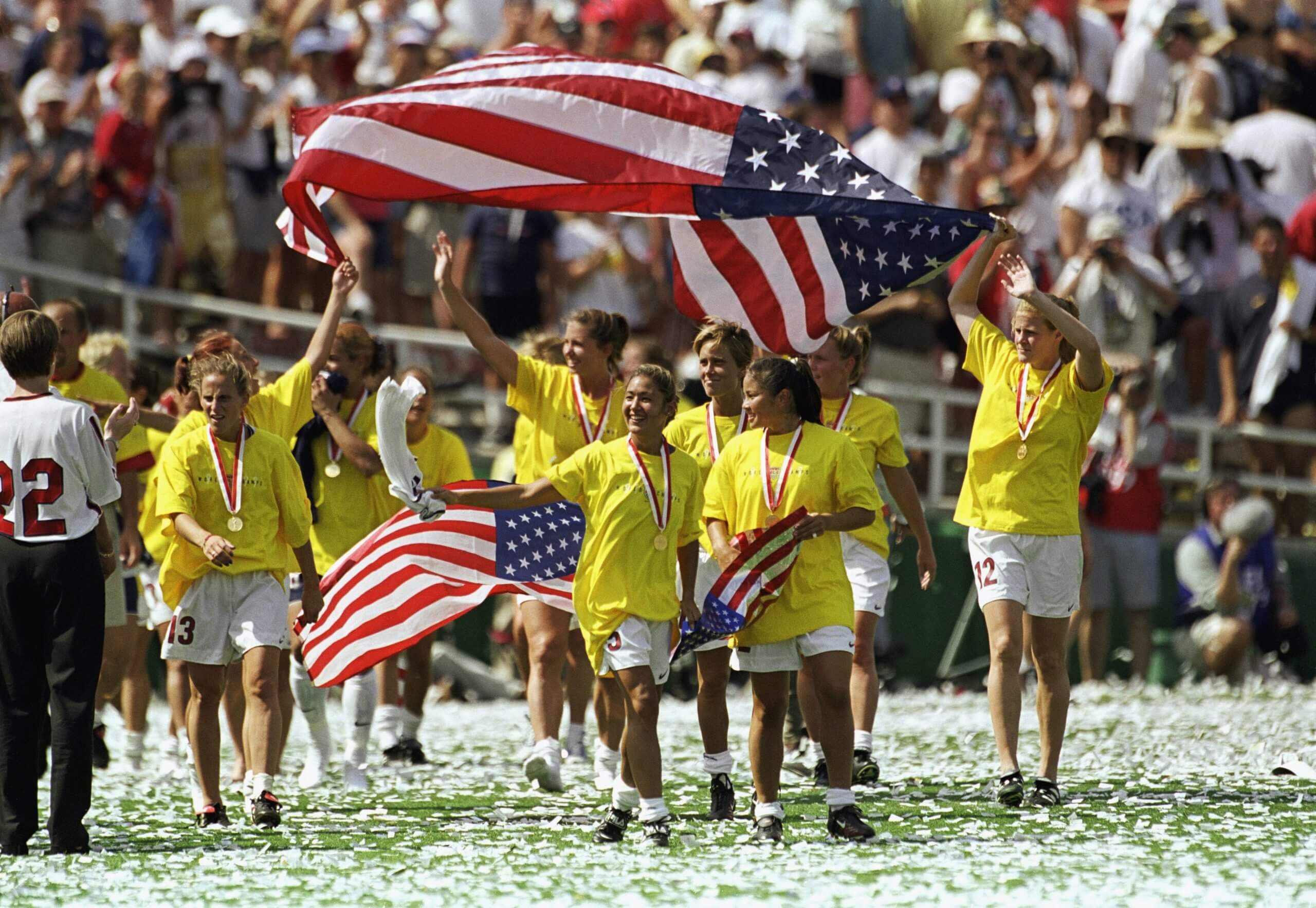 Team USA members wave American flags as they walk across the field in celebration of their victory over Team China in the 1999 FIFA Women's World Cup.