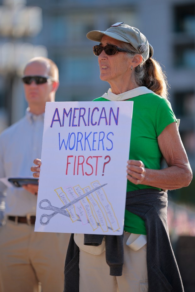 Current and former federal workers and their supporters rally against the Trump Administration