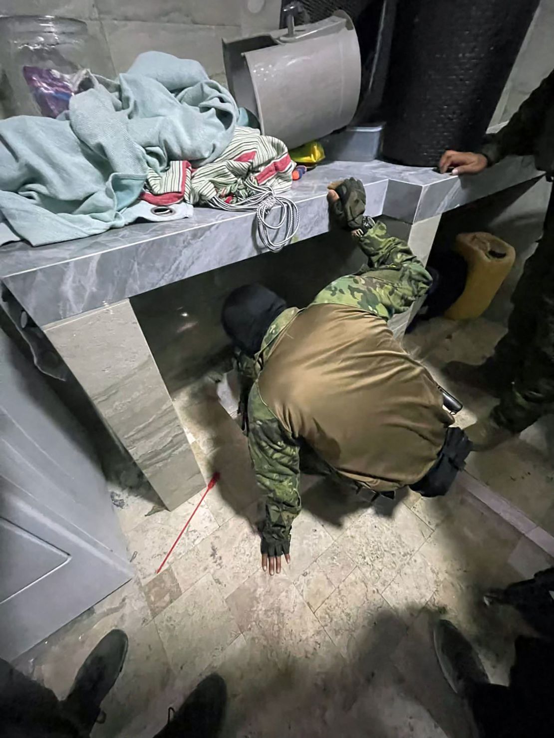 This handout picture released by the Ecuadorean Army shows a member of the army searching the hideout of drug trafficker Adolfo Macias, alias Fito, after he was recaptured in Manta, Manabi Province, Ecuador, on June 25, 2025.