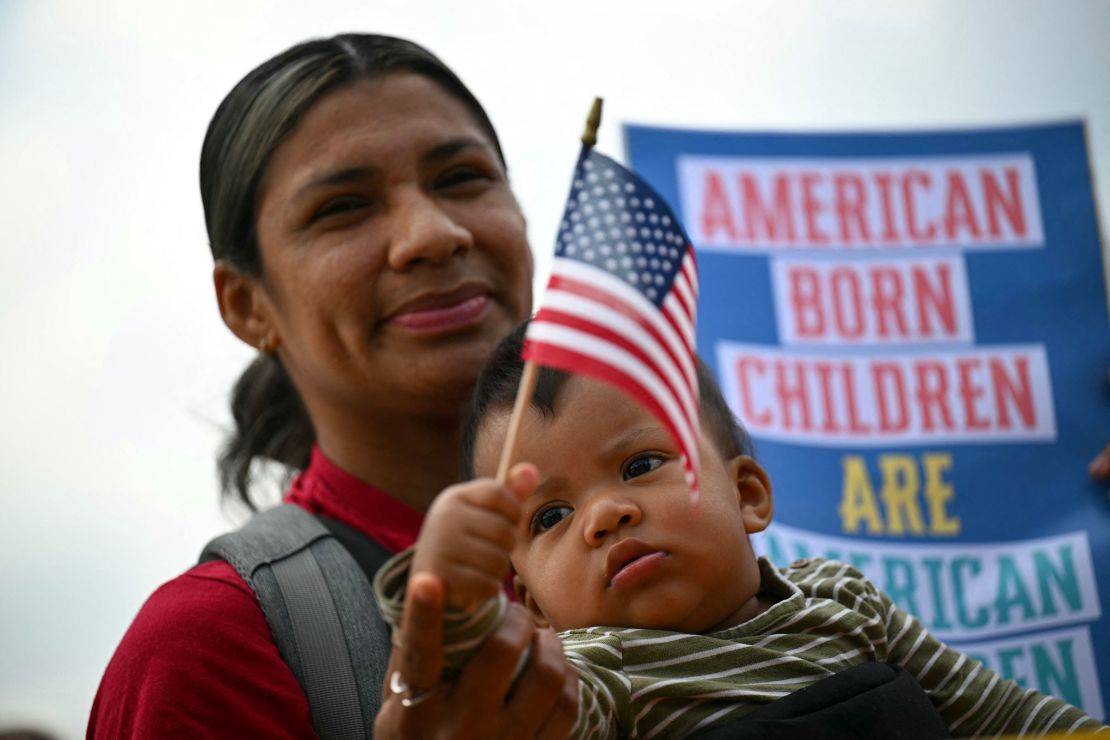 Olga Urbina and her 9-month-old son Ares Webster participate in a protest outside the US Supreme Court over President Donald Trump