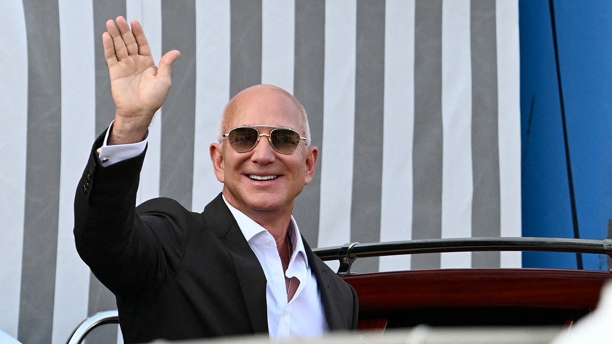 Jeff Bezos waving to photographers in Venice.