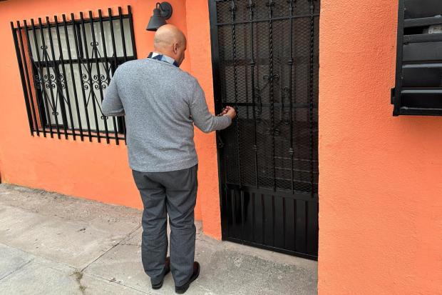 A Cuban man who self-deported opens a door in Ciudad Juárez, Mexico.