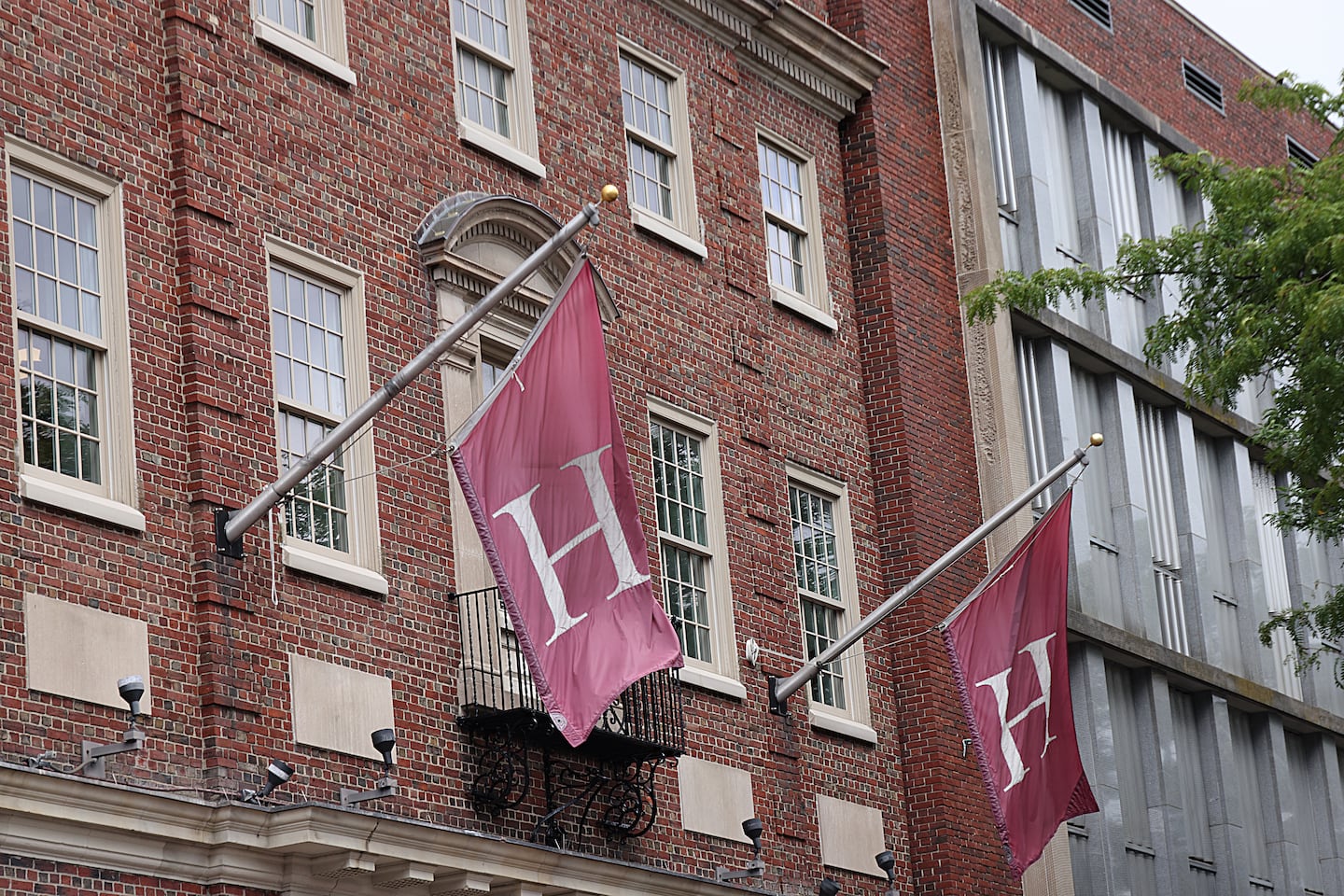 Flags fly over the Coop at Harvard University. Lawyers for the Department of Justice on Wednesday cited the government shutdown in its request for an extension of all pending deadlines in Harvard University’s lawsuit. 