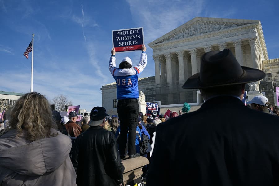 A demonstrators holds up a "Protect Women's Sports" sign outside the Supreme Court 