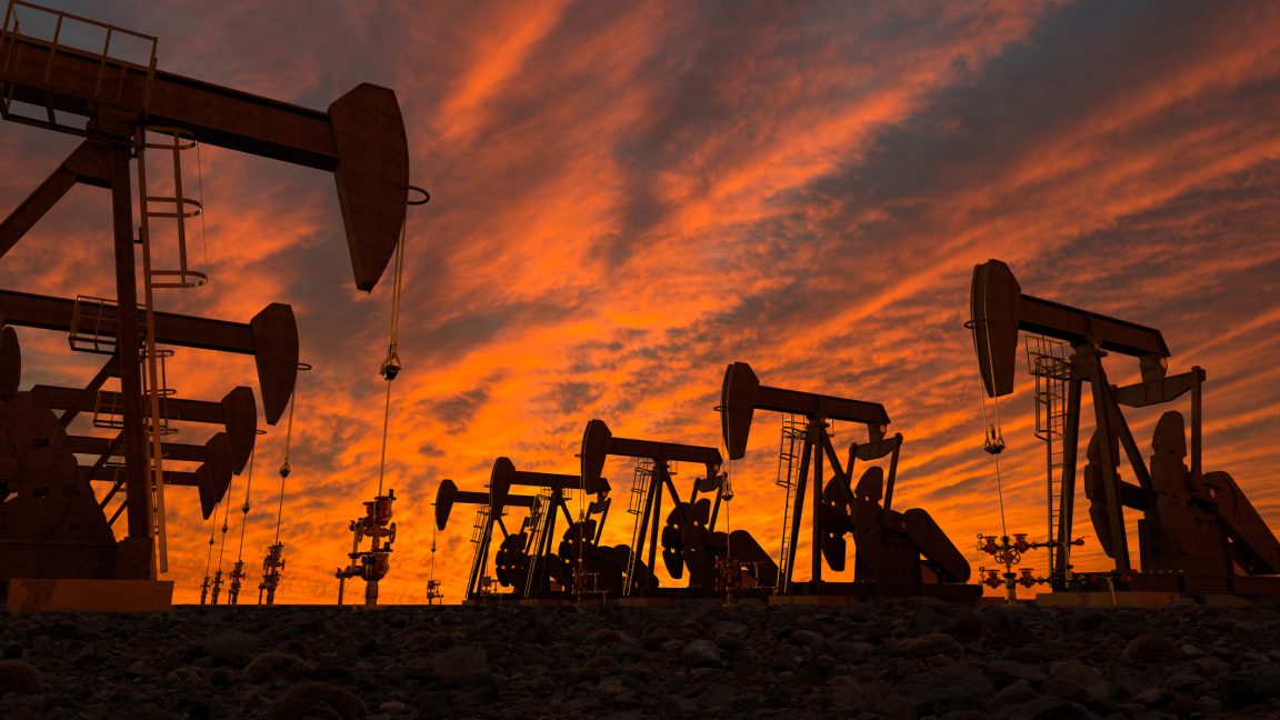 Silhouette Oil Pumps On Field Against Cloudy Sky During Sunset