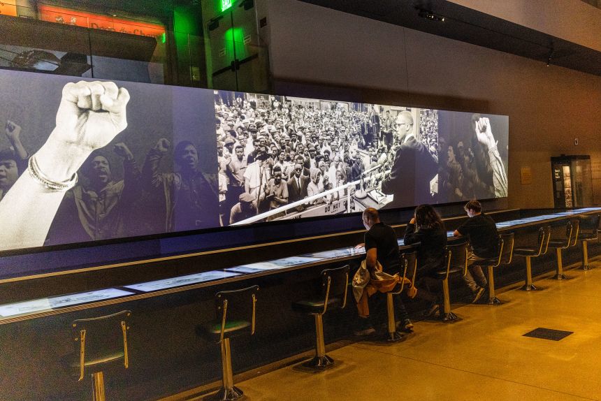 An exhibit of a segregated lunch counter displays videos from the civil rights movement at the Smithsonian National Museum of African American History and Culture, on April 4.