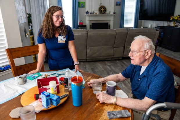 Hannah LaVine, registered nurse case manager, checks in with Robert "Bob" Hamlin at his son and daughter-in-law